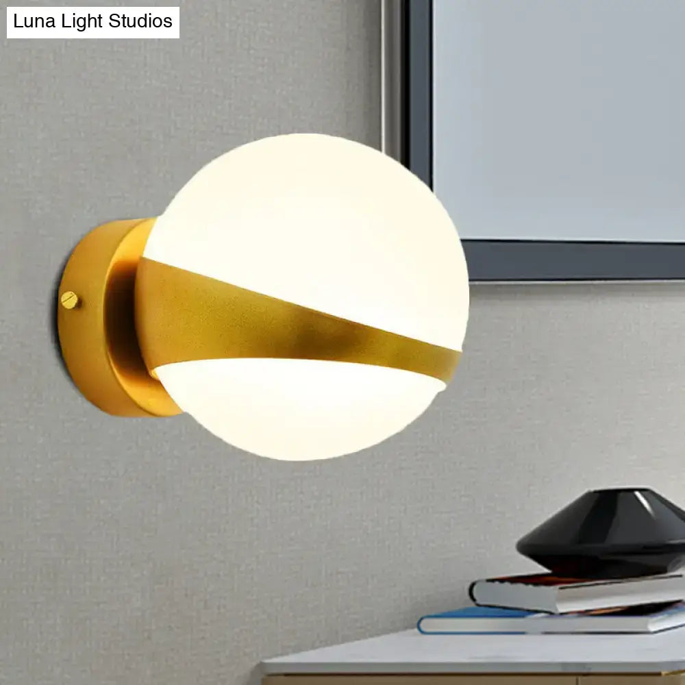 Modern gold frosted glass wall sconce with direct wired installation featuring a matte white diffuser and sleek design