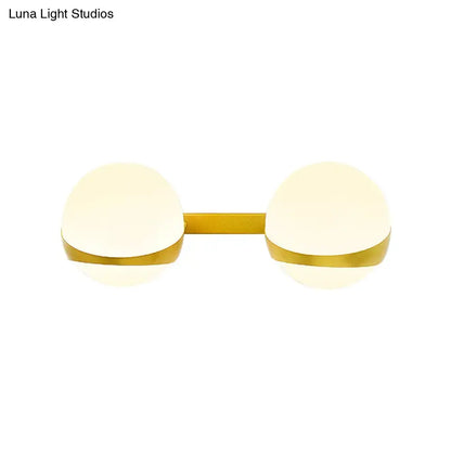 Modern gold wall sconce with two frosted glass globe shades direct wired for bedroom lighting