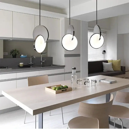 Three modern pendant lights with geometric circle frosted glass shades and black metal frames for dining room decorbites geometric circle