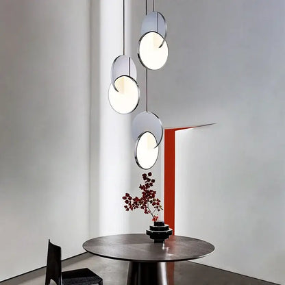 Modern chrome-finished pendant light with overlapping geometric circle discs for minimalist dining decorbites geometric circle