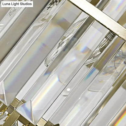 Modern gold geometric wall lamp featuring clear crystal prisms in polished gold-toned metal sconce fixture