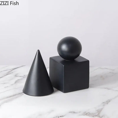 Modern black matte geometric decor set featuring a cube round statue with a cone and sphere for living room display