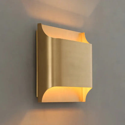 Brass-finished modern gold geometric led wall sconce with curved design and g9 bulb base for warm bedroom lighting