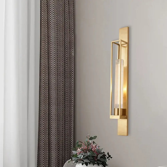 Modern gold wall mount lamp with rectangular geometric metal frame and clear ribbed glass shade for bedroom use
