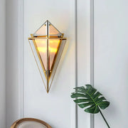 Modern gold geometric wall sconce with amber triangular glass panels and warm glowing light for living room use