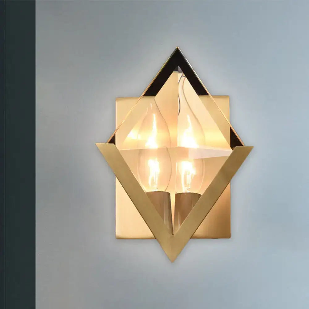Modern style gold-toned geometric wall sconce with clear crystal accents and two exposed filament bulbs for bedroom lighting