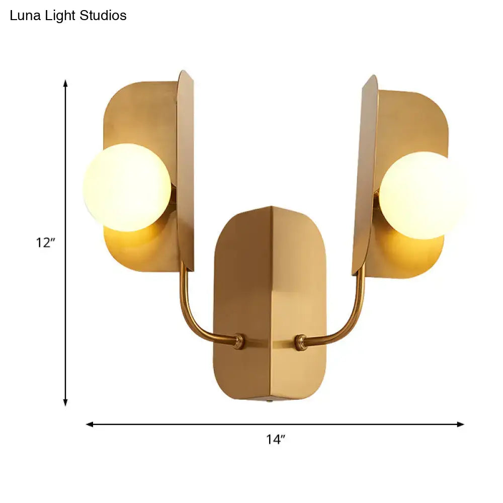 Modern gold wall sconce light with two frosted glass bulbs and angular metal arms for living room lighting