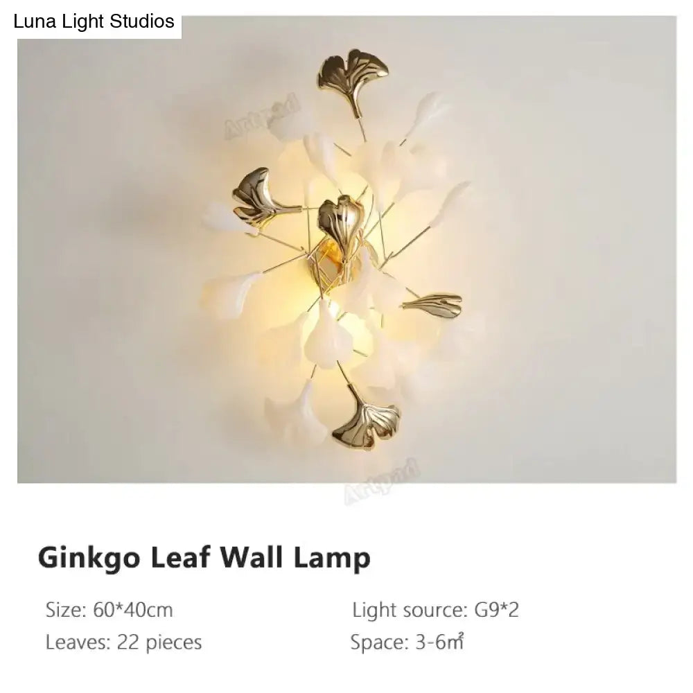 Modern gold ginkgo leaf porcelain wall sconce with central brass fixture and 22 translucent white petals tipped in gold
