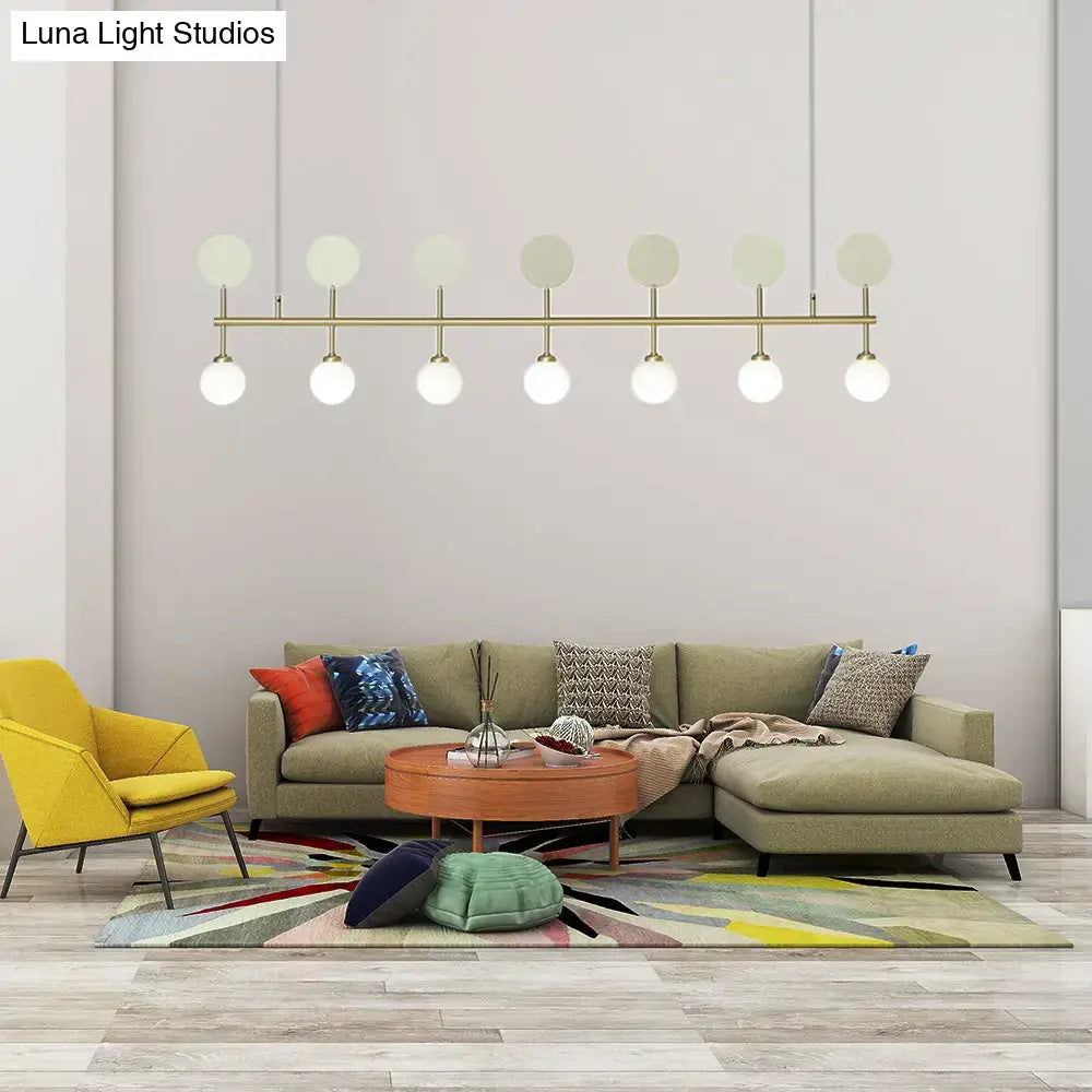 Modern gold-toned DecorBites™ ceiling light with seven frosted glass ball bulbs for dining room island lighting