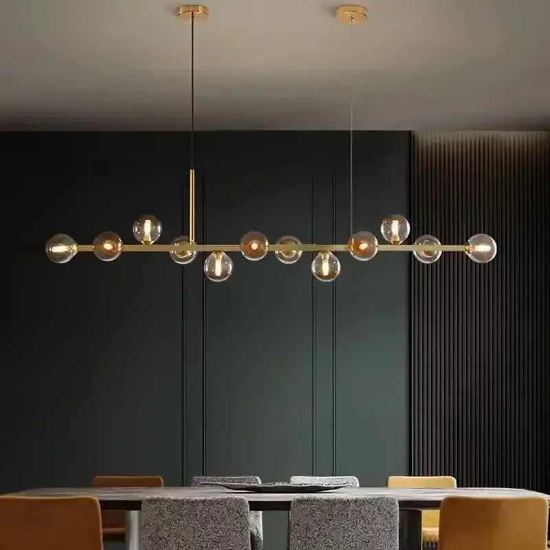 Modern gold glass ball led pendant lights featuring multiple spherical bulbs on a sleek horizontal bar for dining decorbites