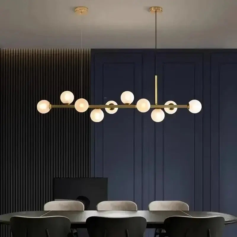 Modern gold glass ball led pendant lights featuring frosted globe bulbs on a sleek horizontal bar for dining decorbites