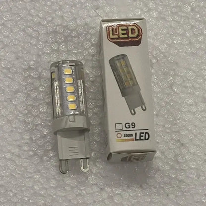 Clear glass ball led bulb with yellowish leds and gray g9 base next to packaging for decorbites glass ball pendant lights