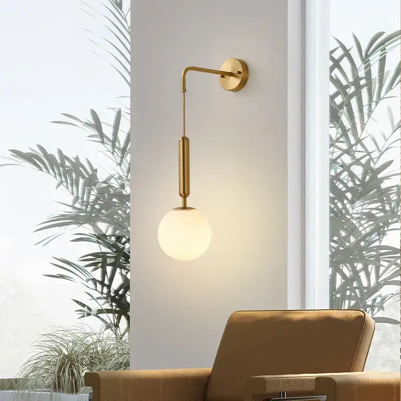 Modern gold wall sconce with sleek curved arm and frosted glass ball led shade for bedroom decorbites decor