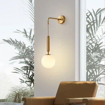 Modern gold wall sconce with sleek curved arm and frosted glass ball led shade for bedroom decorbites decor