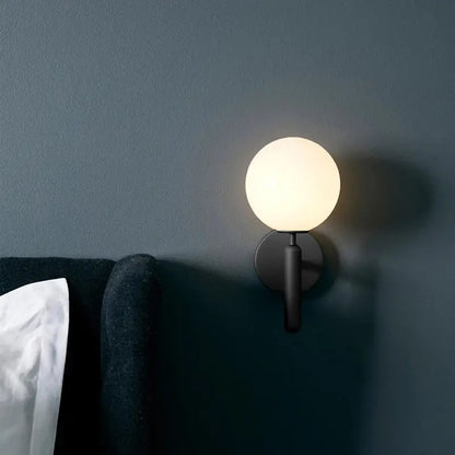 A sleek black wall sconce with frosted glass globe for modern gold glass ball mirror wall lights decorbites bedroom use