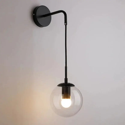 Black metal wall sconce with clear glass globe shade complementing decorbites glass ball pendant chandelier lighting