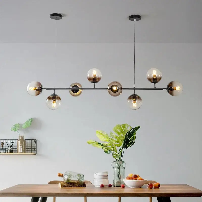 Modern black metal ball pendant chandelier with spherical amber glass globes and exposed filament bulbs for dining room decorbites glass ball