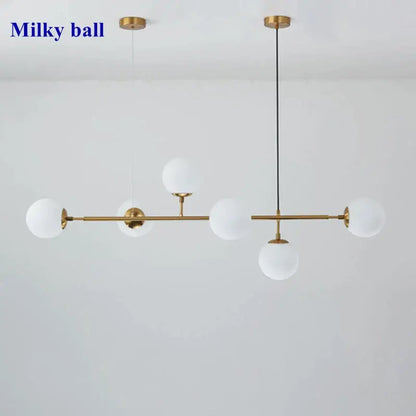 Modern gold glass ball pendant chandelier with five frosted white orbs suspended by rods and cords for dining room decorbites glass ball