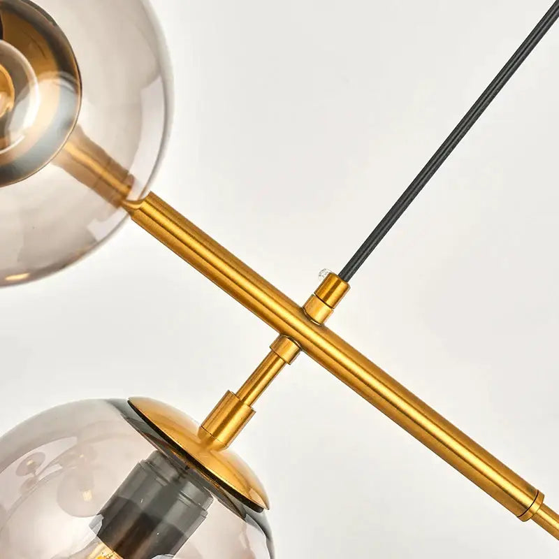 Modern gold glass ball pendant chandelier with gold-toned metal arms and smoked glass globes for dining room decorbites glass ball