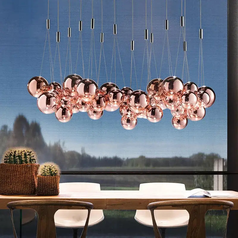 Modern gold glass ball pendant chandelier featuring a rose gold spherical pendant light with reflective glass orbs