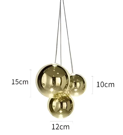 Modern gold glass ball pendant chandelier featuring a gold-toned spherical pendant light with reflective finish and hanging chains