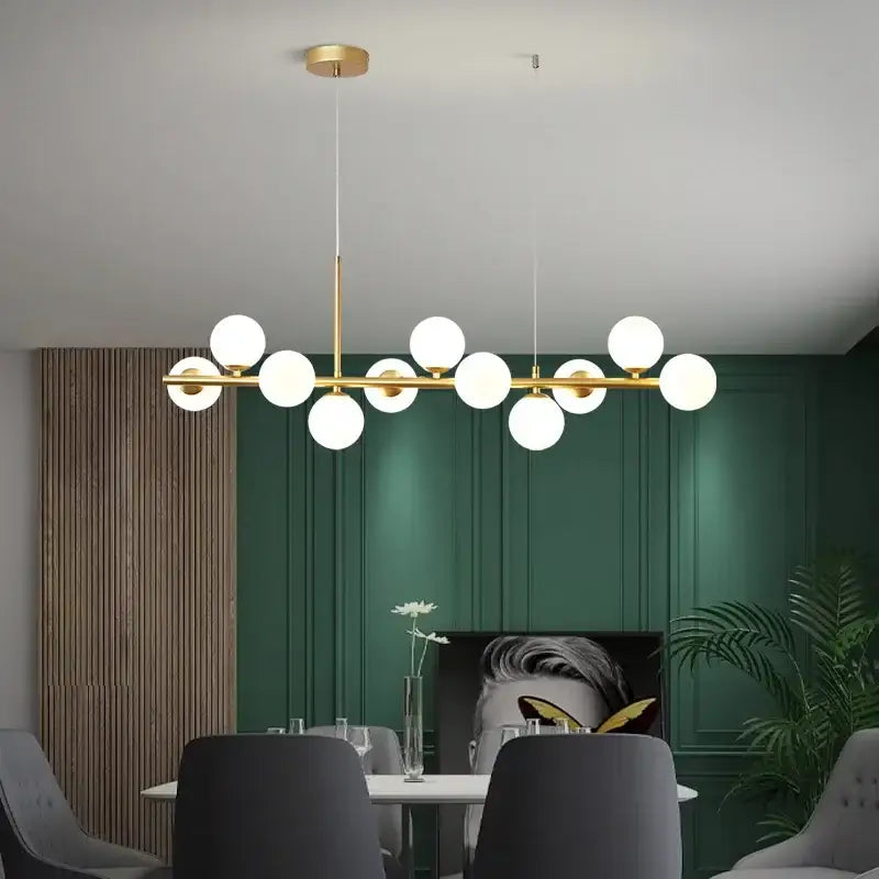 Modern gold glass ball pendant light chandelier with frosted globe bulbs in linear design for dining room decorbites