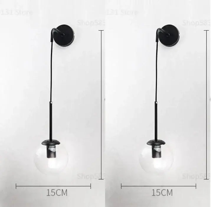 Black wall lamp with clear glass ball globe and slender metal stem for modern bedroom decorbites glass ball sconce
