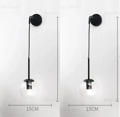 Black wall lamp with clear glass ball globe and slender metal stem for modern bedroom decorbites glass ball sconce