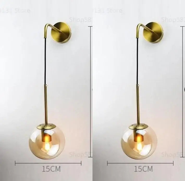 Modern gold glass ball wall lamp with brass finish and clear glass globe featuring an exposed bulb for bedroom decorbites glass ball
