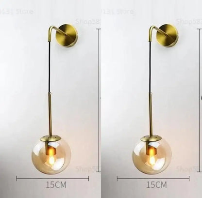 Modern gold glass ball wall lamp with brass finish and clear glass globe featuring an exposed bulb for bedroom decorbites glass ball