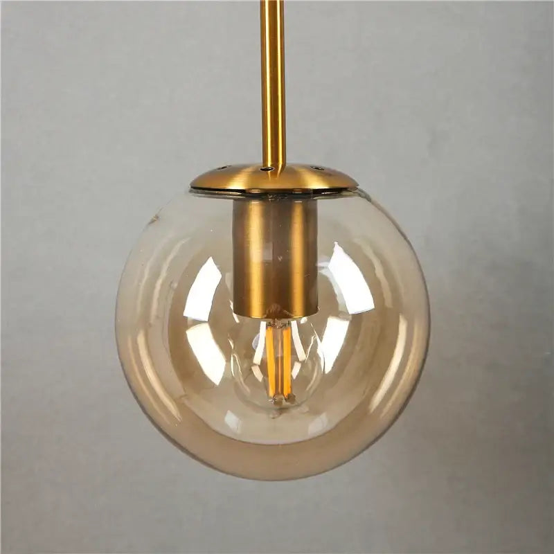 Modern gold glass ball wall lamp featuring a clear glass globe and exposed filament bulb for elegant decorbites glass ball decor