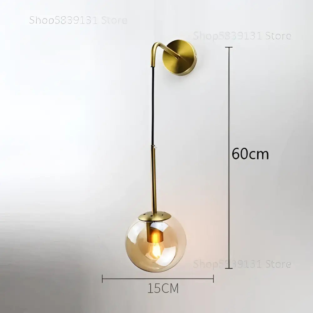 Modern gold wall lamp with glass ball globe and slender metal arm for elegant bedroom decorbites glass ball design