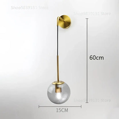 Modern gold glass ball wall lamp featuring a gold-toned metal stem and clear glass globe for elegant decorbites glass ball decor