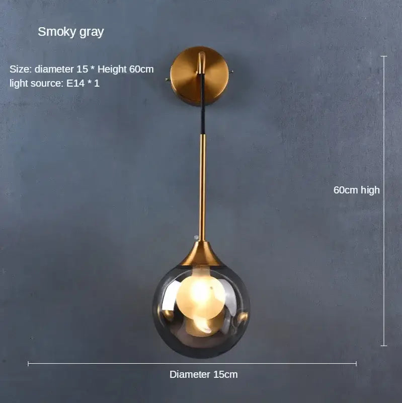 A modern wall lamp with a smoked glass ball gold globe and brass finish perfect for bedroom decorbites glass ball