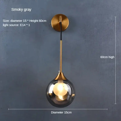 A modern wall lamp with a smoked glass ball gold globe and brass finish perfect for bedroom decorbites glass ball