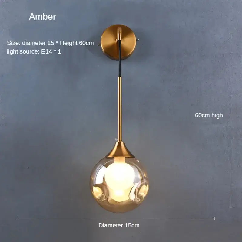 Modern gold glass ball wall lamp with a spherical amber glass globe and brass-finished decorbites glass ball mount