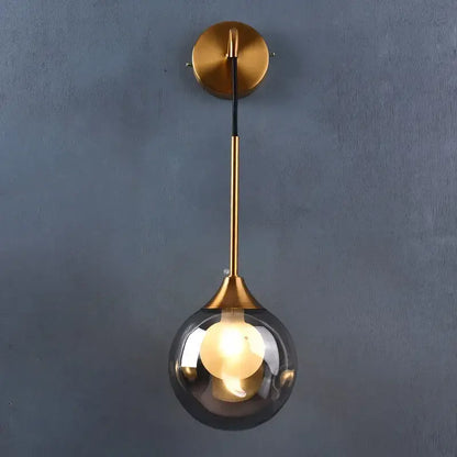 Modern gold glass ball wall lamp with a sleek spherical smoked glass shade and minimalist metal stem for decorbites glass ball decor