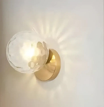 Modern gold glass ball wall lamp with clear faceted globe and warm golden metal base for bedroom decorbites glass ball wall