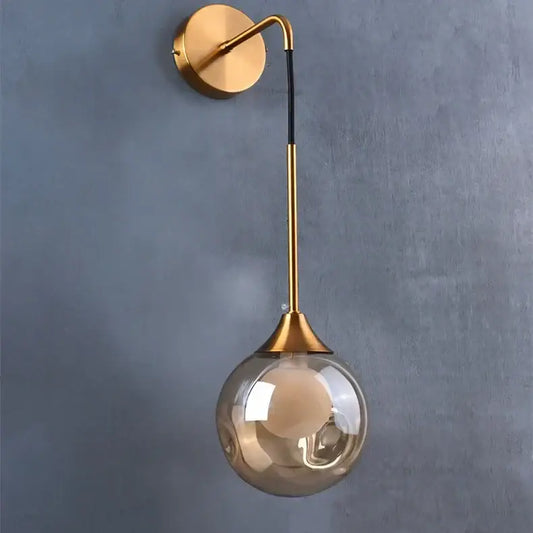 Modern gold glass ball wall sconce with a curved arm and smoked glass shade for bedroom decorbites glass ball lighting