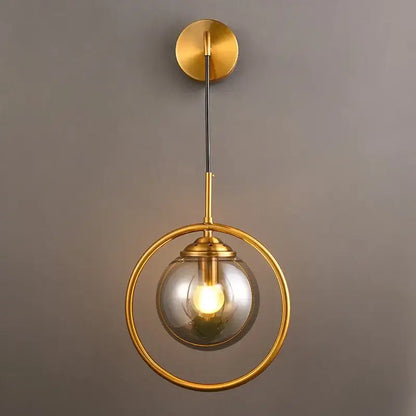 Modern gold glass ball wall sconce light fixture with circular frame and clear glass globe for stylish decorbites bedroom lighting
