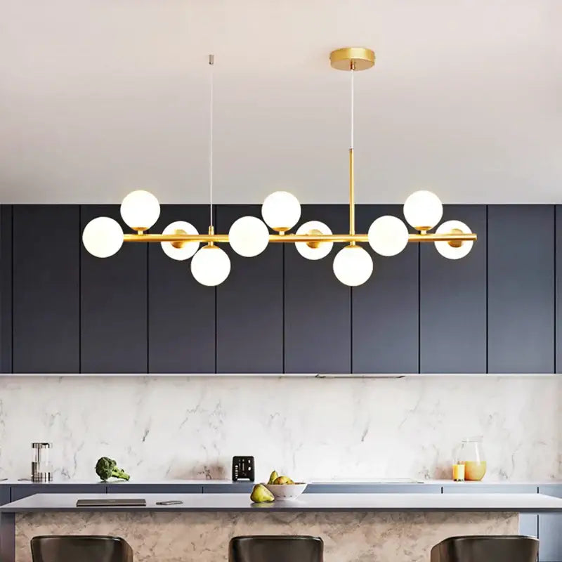 Modern gold glass globe pendant light with metal structure and spherical bulbs as a dining room focal point