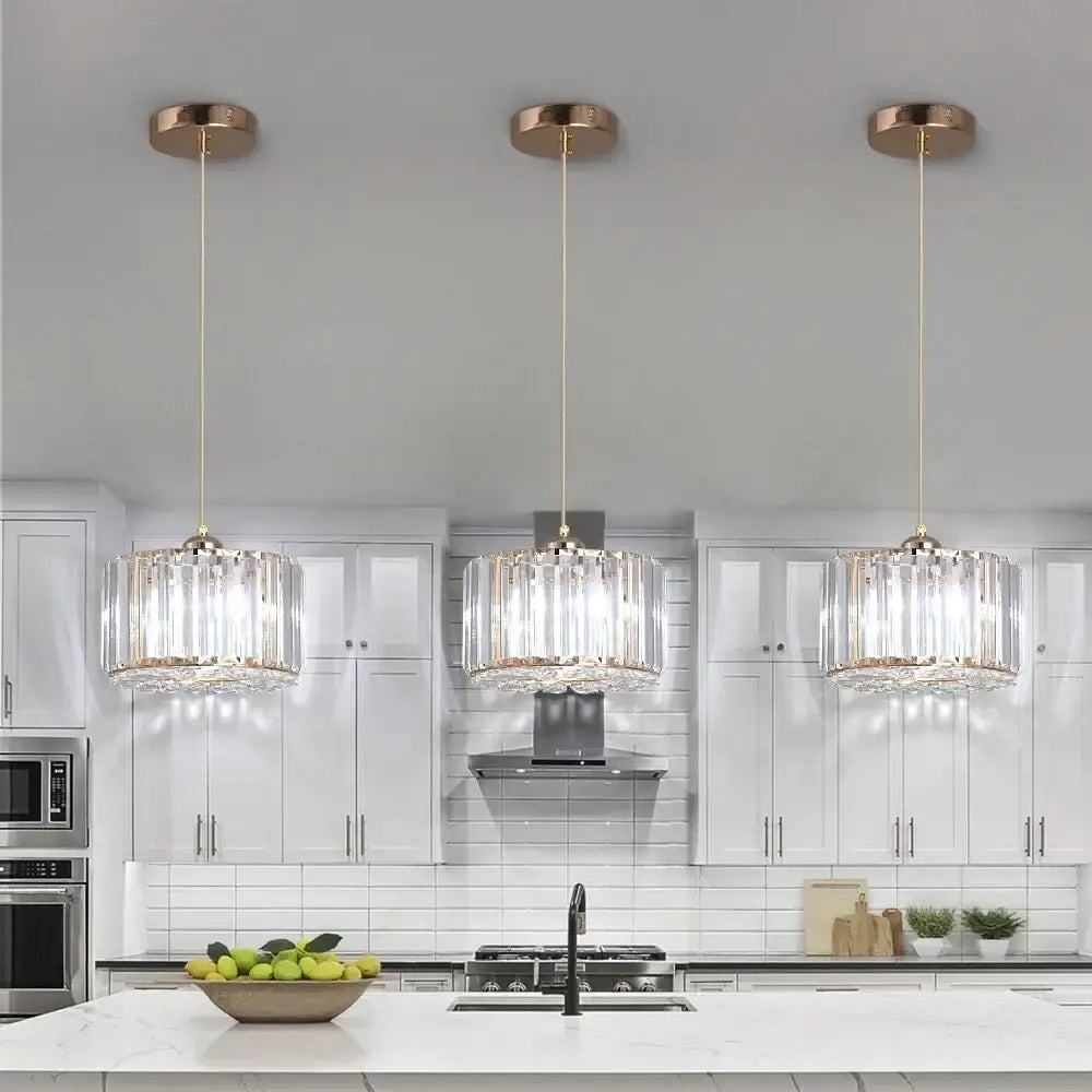 Three elegant rose gold glass led chandelier ceiling lights with cascading crystal shades above a modern kitchen island