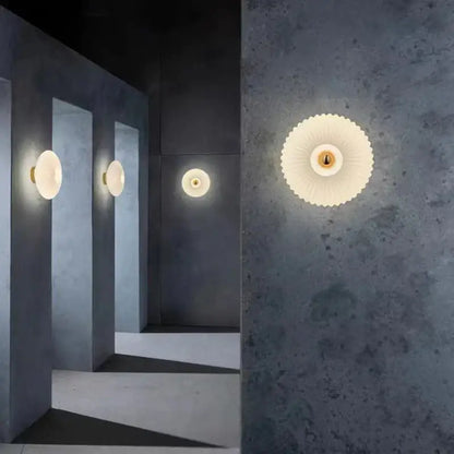 Cream-colored petal-shaped wall lamps with gold-toned center featuring modern glass ripple led design for bedroom decor