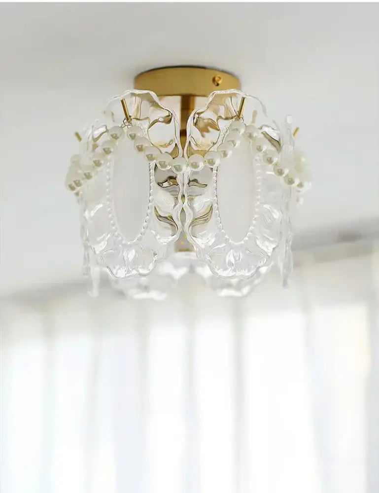 Modern gold glass shade ceiling light featuring a clear glass chandelier with gold-toned base and floral patterns