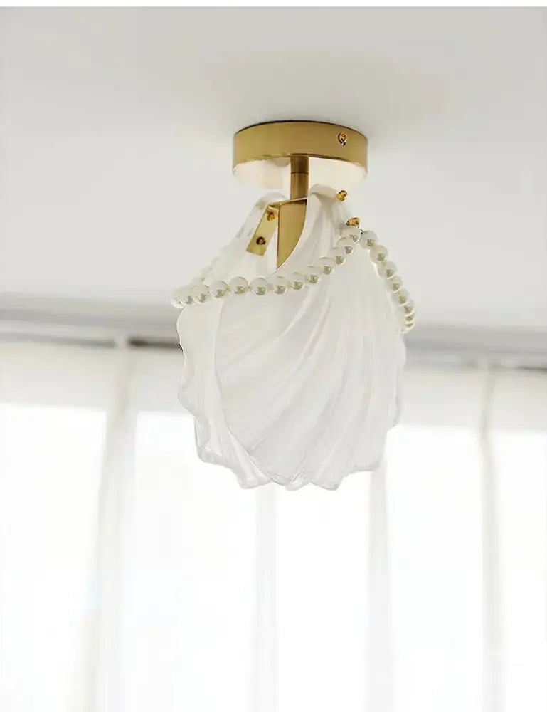 Modern gold glass shade ceiling light featuring a white translucent seashell shape and pearl bead chandelier design