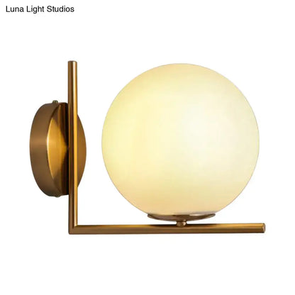 Brass-finished modern wall sconce with frosted opal glass globe shade suitable for led incandescent fluorescent lighting