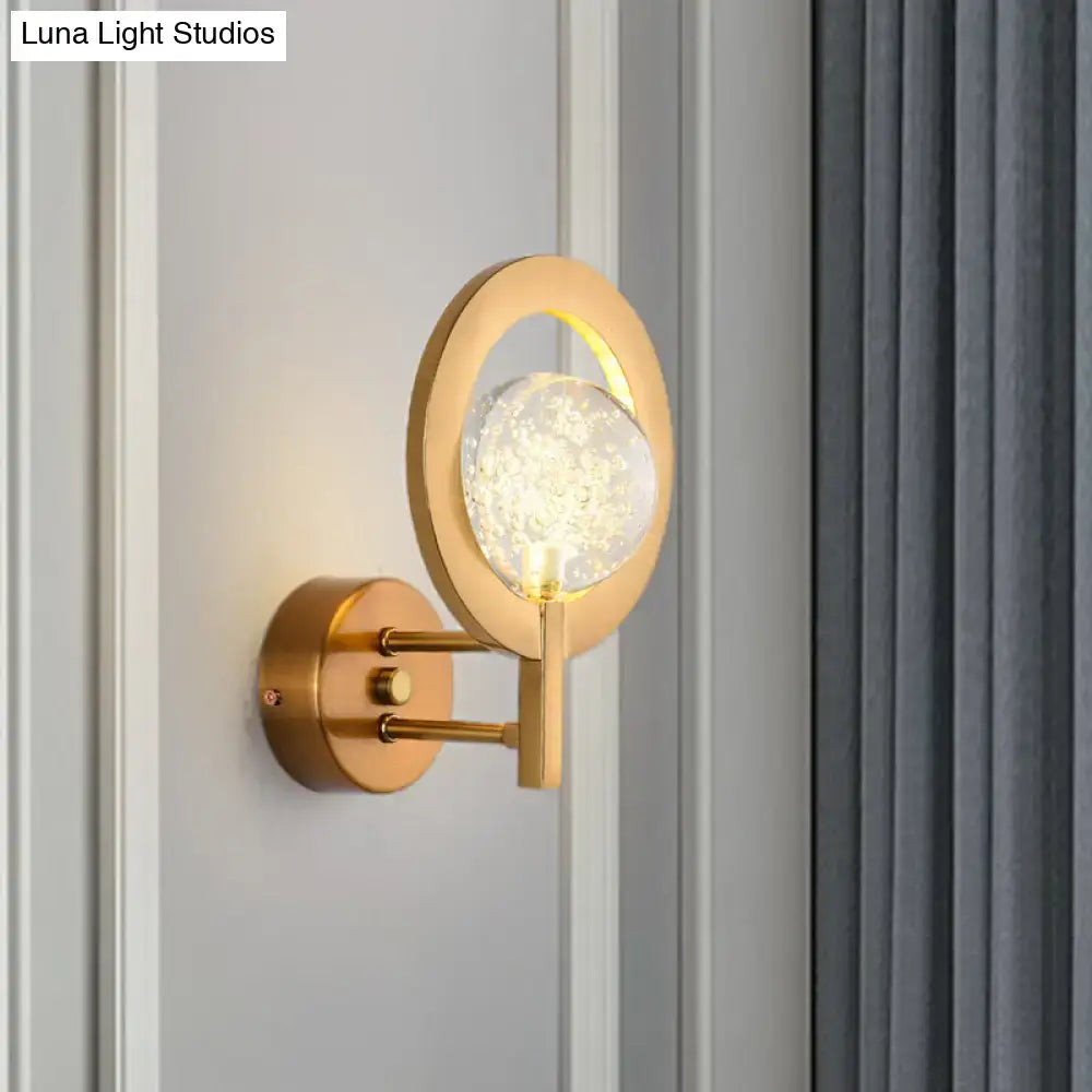 Modern gold globe wall lamp with a gold-toned circular base and faceted clear crystal globe for 110v-120v use