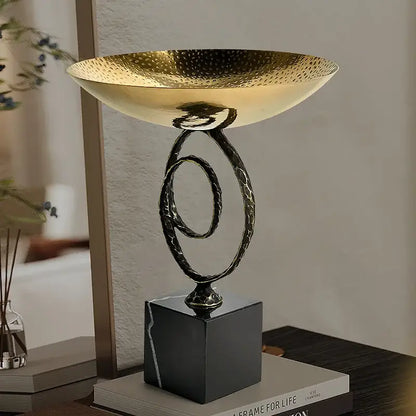 Modern gold hammered fruit bowl tray with black marble base and twisted metal stand for dining room display