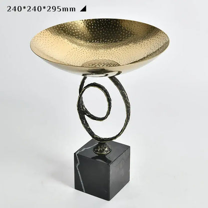 Modern gold hammered fruit bowl tray with twisted black metal stand and dark marble base for elegant dining room display