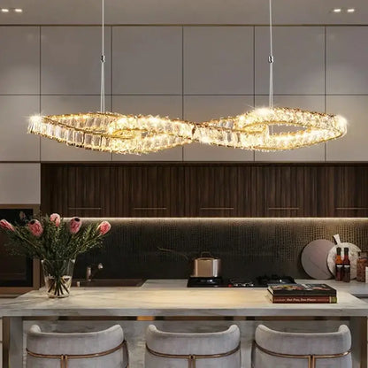 Modern gold infinity crystal led pendant chandelier with decorbites crystal led accents above kitchen island